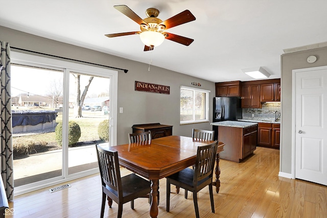 dining room with sink, light hardwood / wood-style floors, and ceiling fan