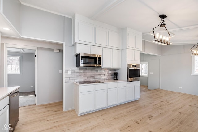 kitchen featuring decorative backsplash, appliances with stainless steel finishes, light countertops, light wood-style floors, and white cabinetry