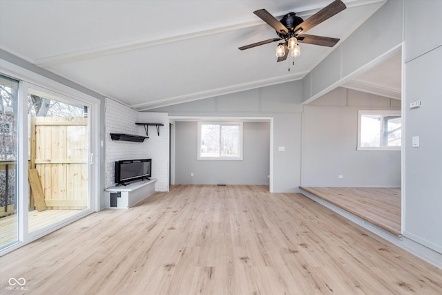 unfurnished living room with lofted ceiling with beams, ceiling fan, a fireplace, and wood finished floors