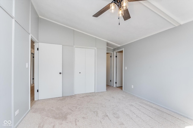 unfurnished bedroom featuring carpet, a closet, vaulted ceiling, and ceiling fan