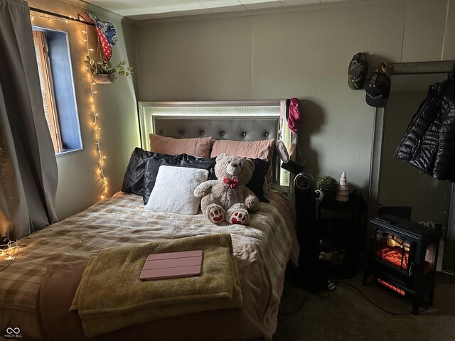 bedroom with a wood stove and carpet