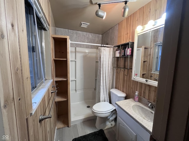 full bath featuring vanity, toilet, a stall shower, visible vents, and wood finished floors