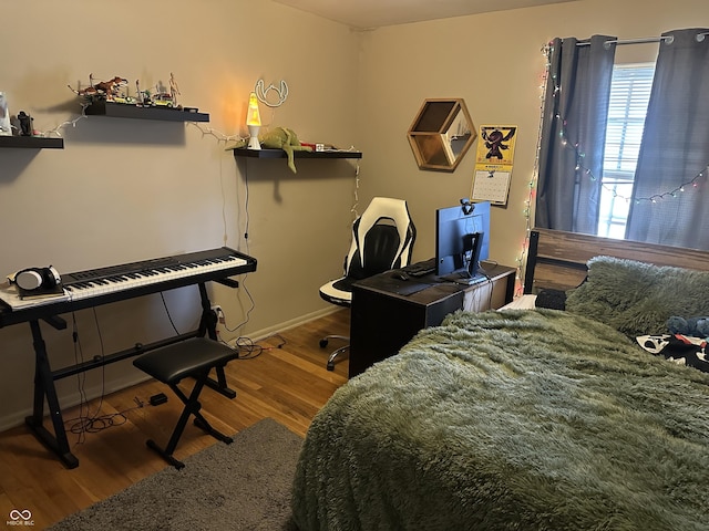bedroom featuring wood finished floors and baseboards