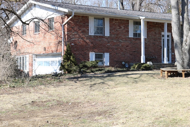 exterior space with an attached garage, roof with shingles, a lawn, and brick siding