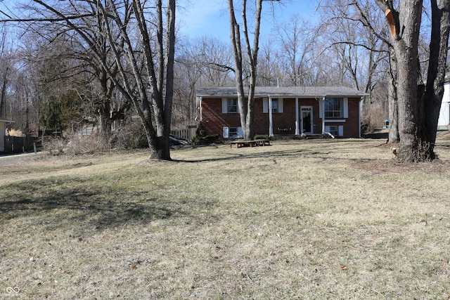 view of front of house with a front yard, central AC, and brick siding