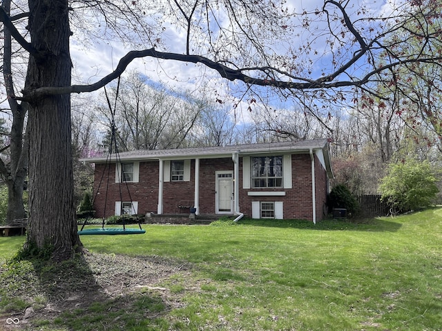 bi-level home with a front yard and brick siding