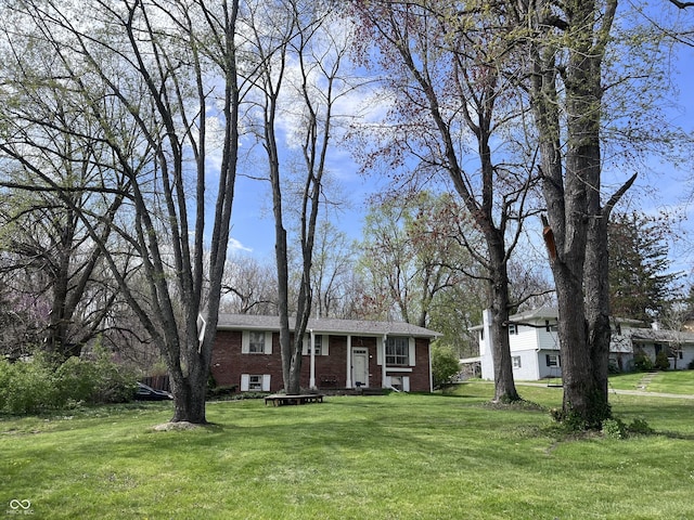 bi-level home with a front lawn and brick siding
