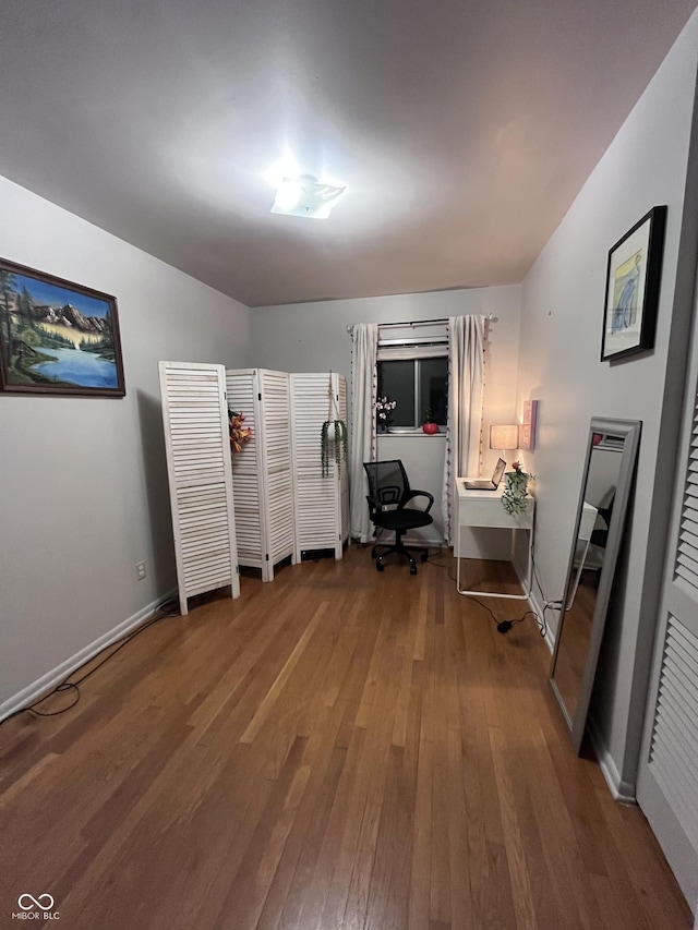 bedroom with hardwood / wood-style floors and baseboards