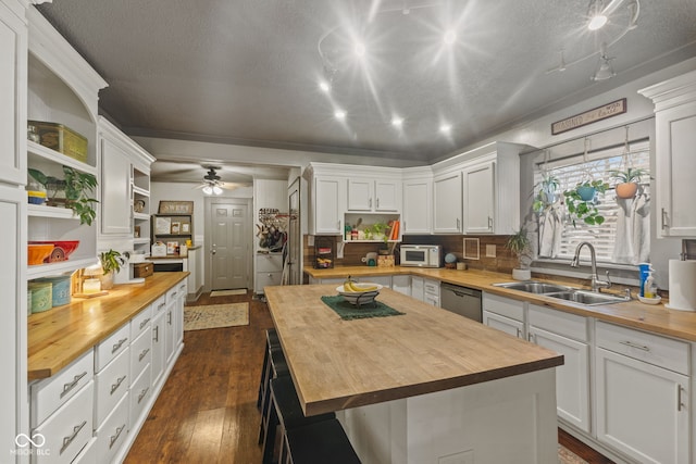kitchen with wood counters, white cabinetry, sink, a center island, and stainless steel appliances