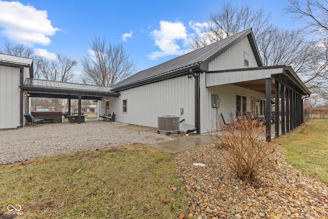 view of home's exterior with cooling unit, a jacuzzi, a lawn, and a patio