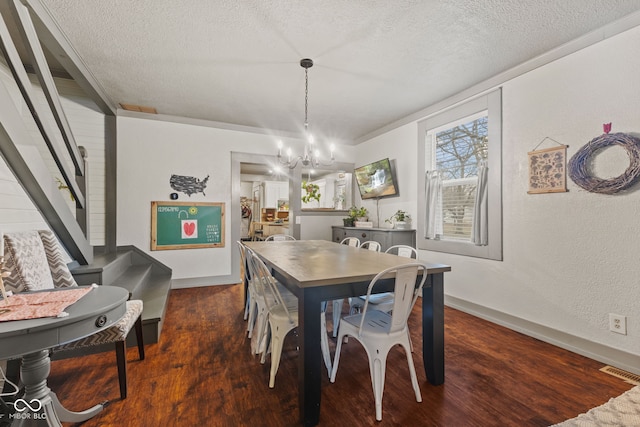 dining space featuring a notable chandelier, dark hardwood / wood-style floors, and a textured ceiling