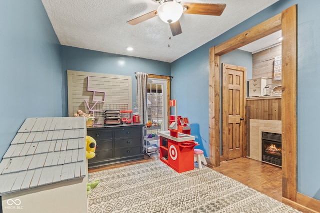 bedroom featuring ceiling fan, light hardwood / wood-style floors, and a textured ceiling