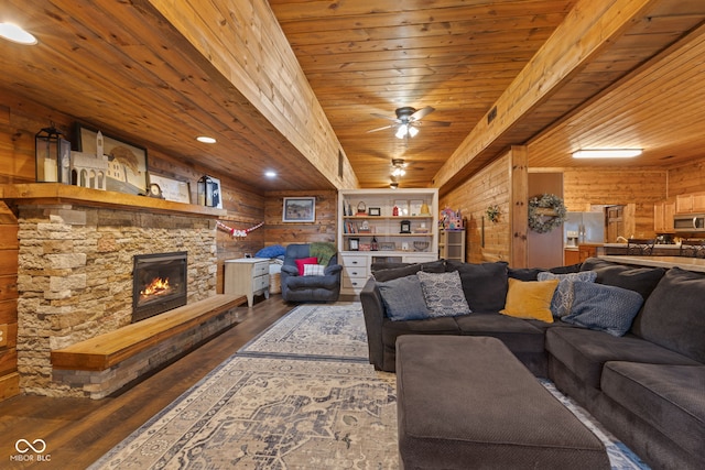 living room with a stone fireplace, hardwood / wood-style floors, wooden walls, ceiling fan, and wood ceiling