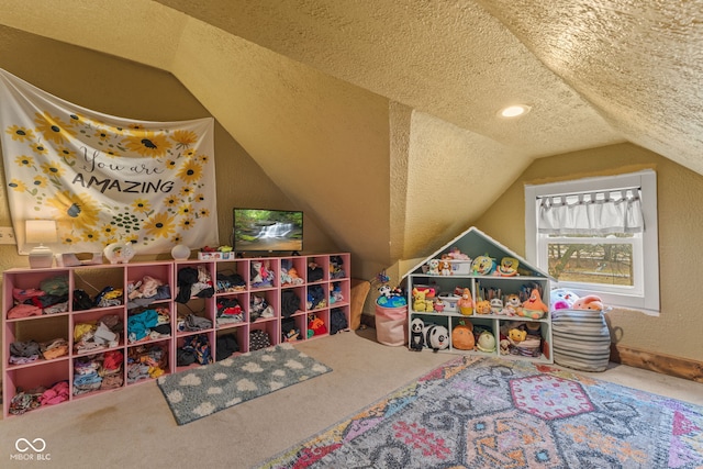 playroom with lofted ceiling, carpet flooring, and a textured ceiling