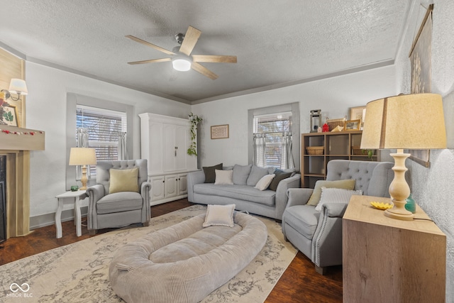 living room featuring dark wood-type flooring, a wealth of natural light, a textured ceiling, and ceiling fan