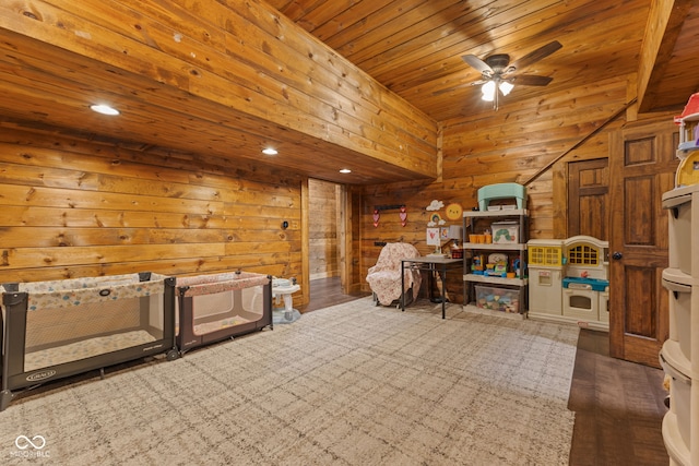 interior space with ceiling fan, wood ceiling, and wood walls