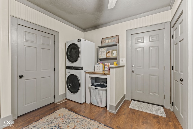 washroom featuring ornamental molding, stacked washing maching and dryer, dark hardwood / wood-style flooring, and a textured ceiling