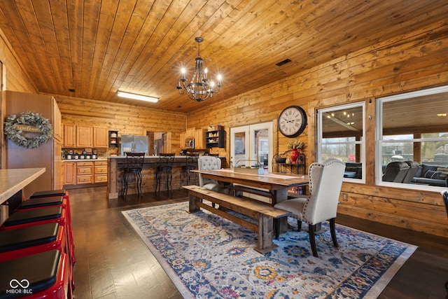 dining area featuring wood walls, dark hardwood / wood-style flooring, a chandelier, wood ceiling, and french doors