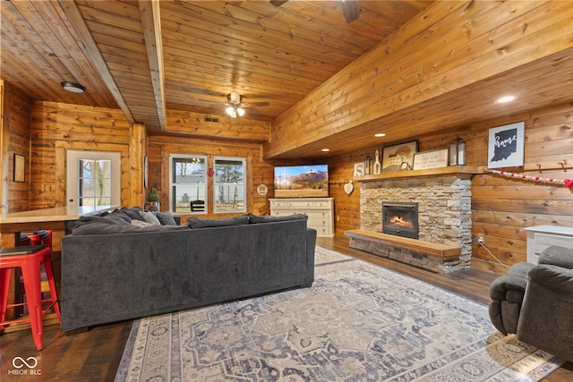 living room featuring wood ceiling, ceiling fan, dark hardwood / wood-style flooring, and a stone fireplace