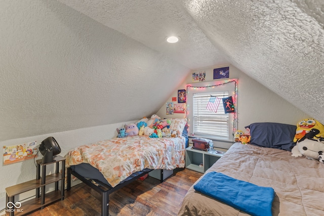 bedroom with lofted ceiling, dark wood-type flooring, and a textured ceiling