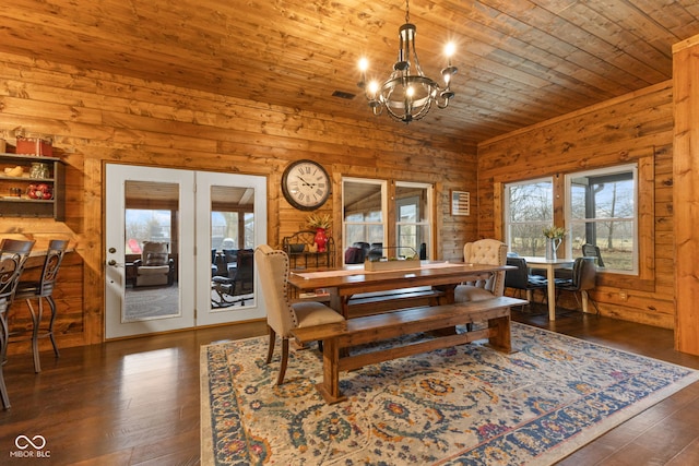 dining room featuring an inviting chandelier, wood walls, dark hardwood / wood-style flooring, and wooden ceiling