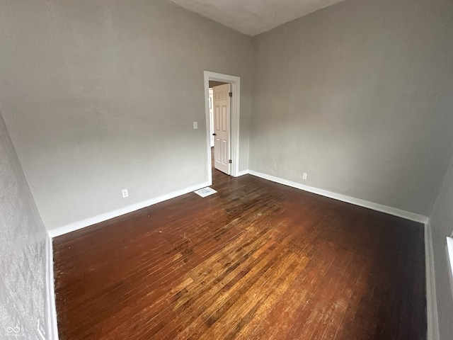 unfurnished room with dark hardwood / wood-style flooring