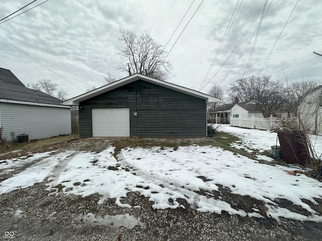 snow covered garage with central AC unit