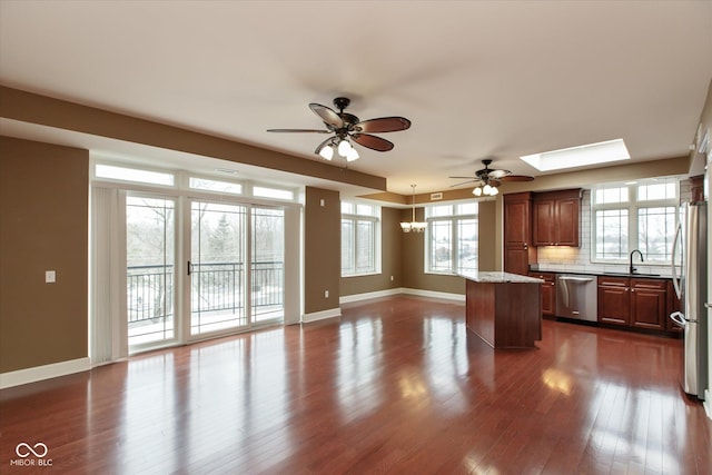 kitchen featuring dark wood-style flooring, decorative backsplash, appliances with stainless steel finishes, open floor plan, and a kitchen island