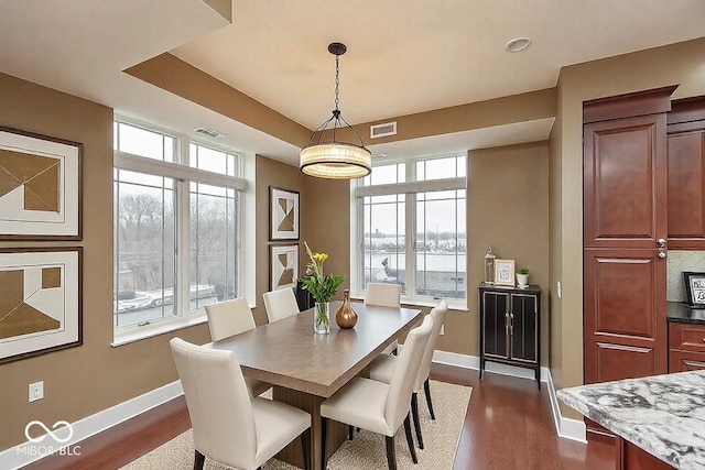 dining room with baseboards, visible vents, and dark wood-style flooring