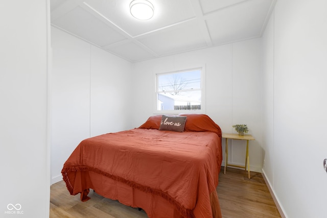 bedroom featuring coffered ceiling and light hardwood / wood-style flooring