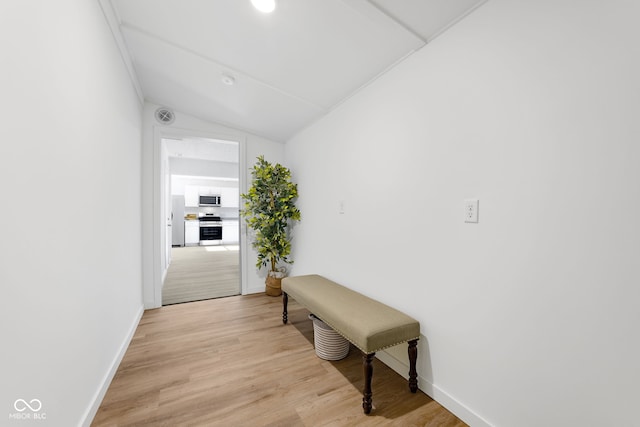 hall featuring lofted ceiling and light hardwood / wood-style flooring