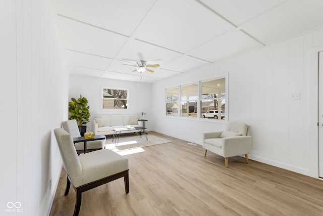 living area with coffered ceiling, light hardwood / wood-style floors, and ceiling fan