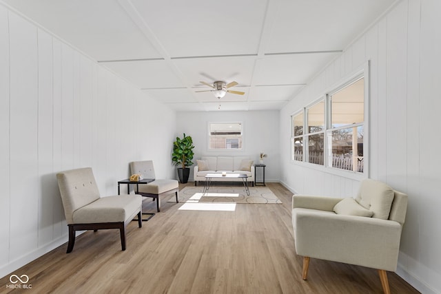 sitting room with ceiling fan, coffered ceiling, and light wood-type flooring