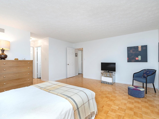 bedroom featuring light parquet flooring and a textured ceiling