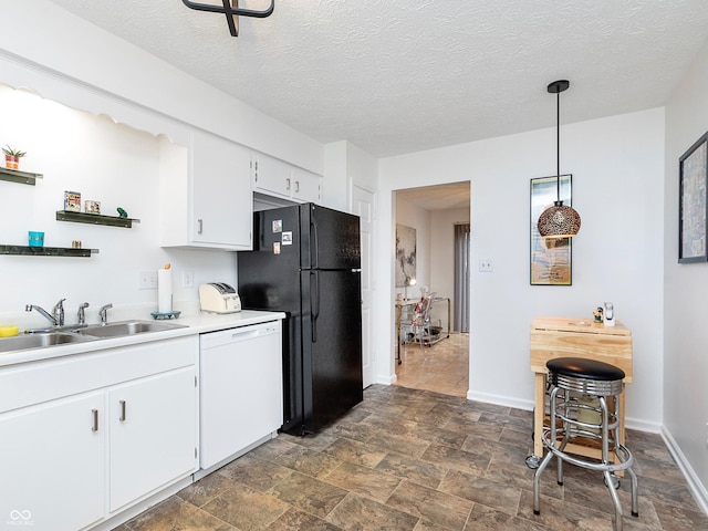 kitchen featuring sink, black fridge, decorative light fixtures, white dishwasher, and white cabinets