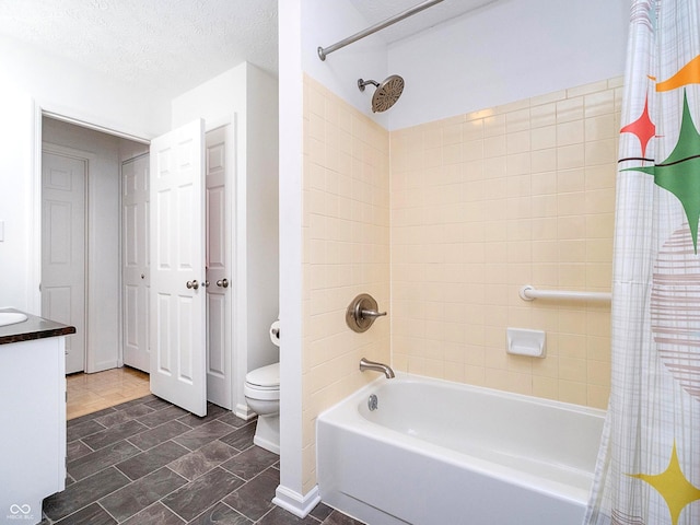 full bathroom featuring shower / bath combo, vanity, a textured ceiling, and toilet