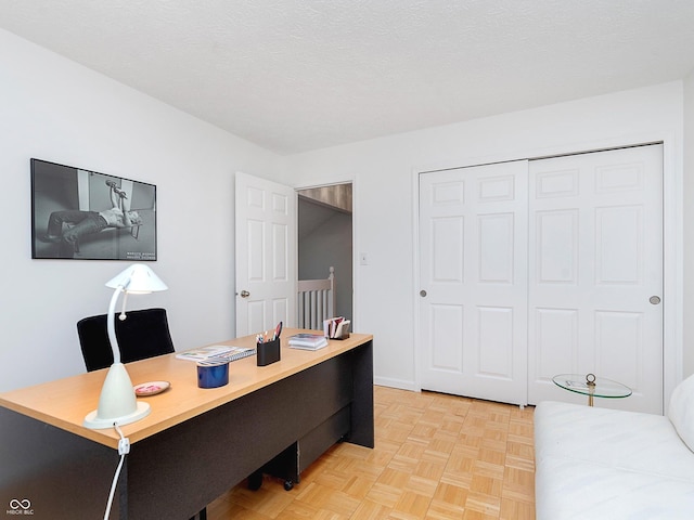 home office featuring light parquet flooring and a textured ceiling