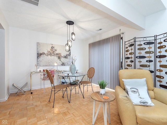 dining room featuring parquet flooring and a textured ceiling