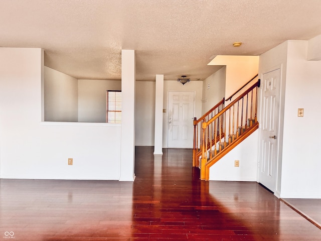 entryway featuring dark hardwood / wood-style flooring and a textured ceiling