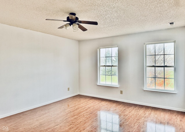 spare room with a textured ceiling, light hardwood / wood-style floors, and ceiling fan