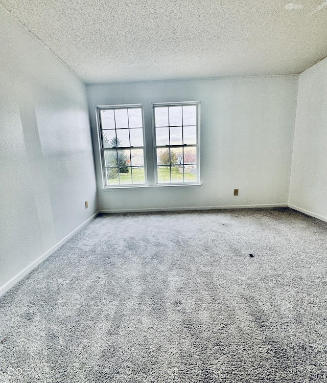 carpeted empty room with a textured ceiling