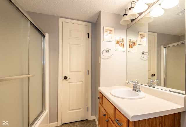 bathroom featuring vanity, a textured ceiling, and shower / bath combination with glass door