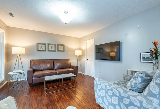 living room featuring dark hardwood / wood-style floors and a textured ceiling