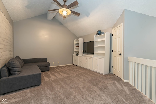 living area with light carpet, vaulted ceiling with beams, a textured ceiling, and ceiling fan