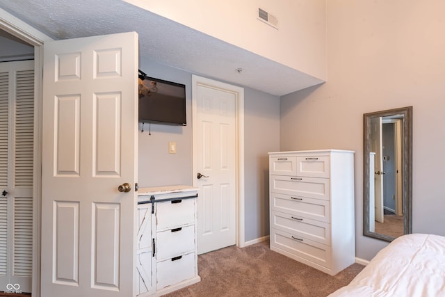 carpeted bedroom with a closet and a textured ceiling