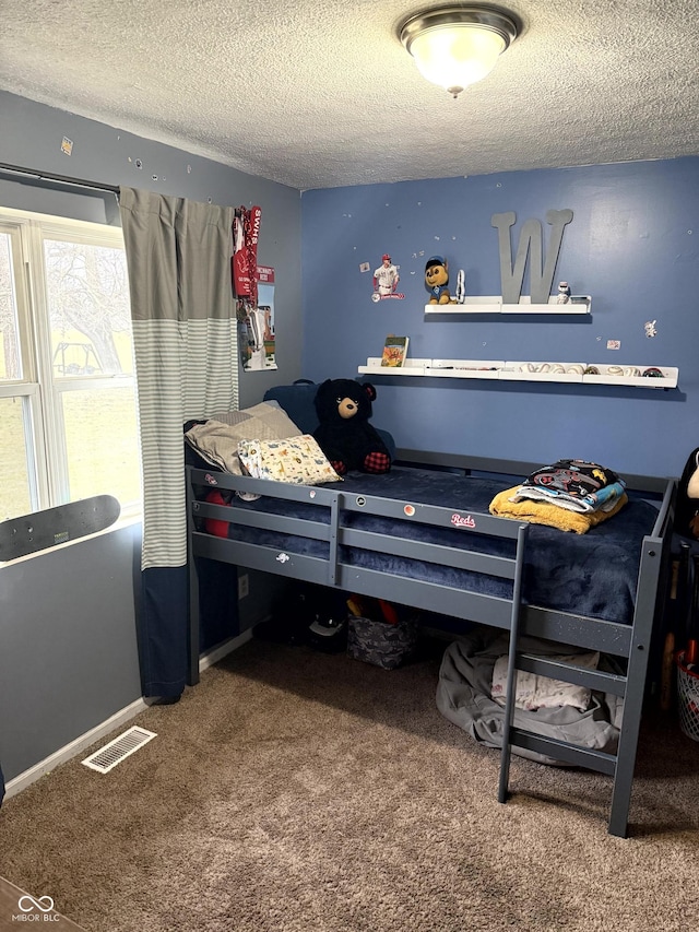 carpeted bedroom featuring a textured ceiling