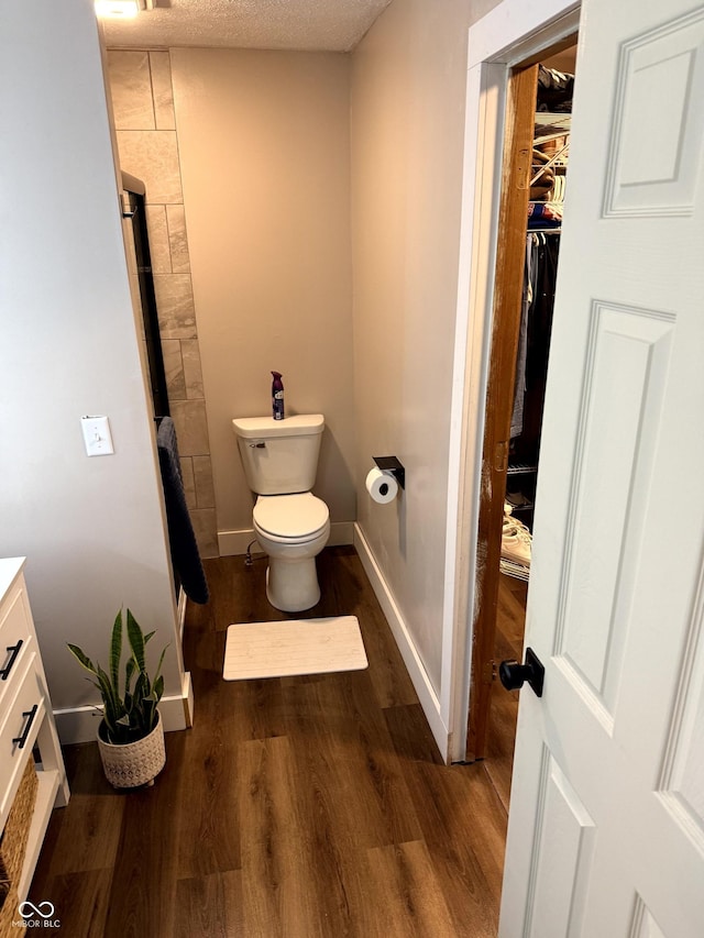 bathroom with vanity, toilet, hardwood / wood-style floors, and a textured ceiling