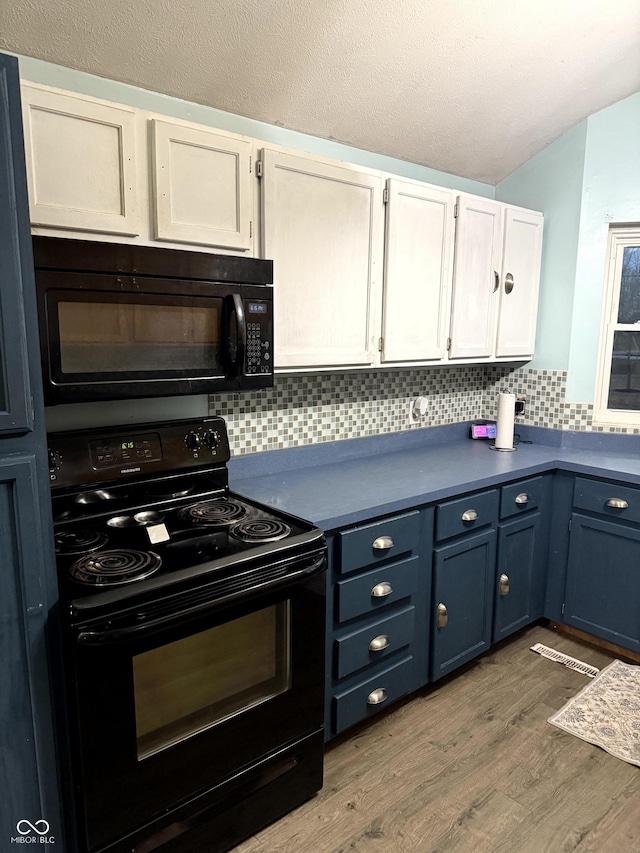 kitchen featuring blue cabinets, white cabinetry, black appliances, hardwood / wood-style flooring, and backsplash