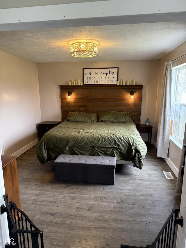 bedroom with hardwood / wood-style flooring and a textured ceiling