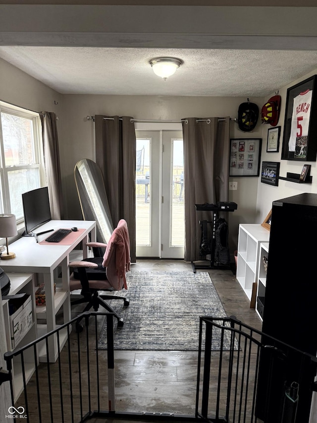 office area with wood-type flooring, a textured ceiling, and french doors